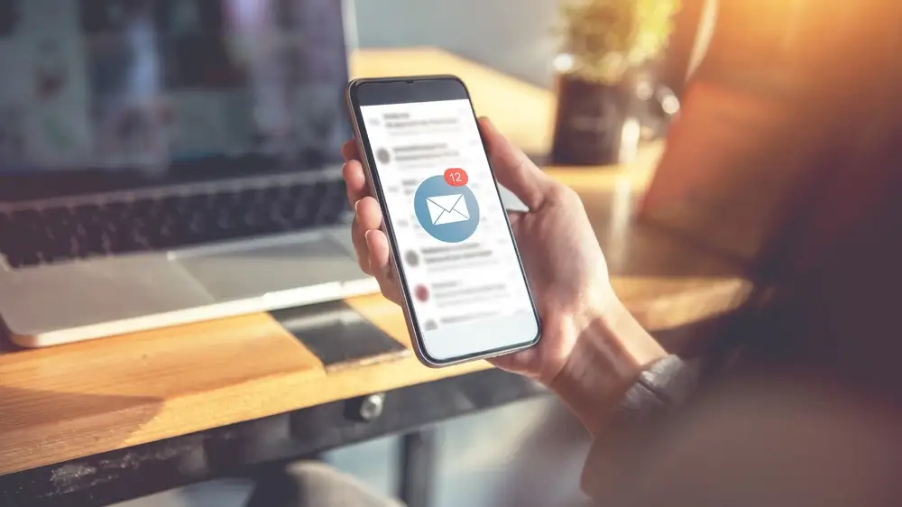 Phone screen shows a new email received - 3 creative ways to add videos to email marketing - Clipchamp Blog
