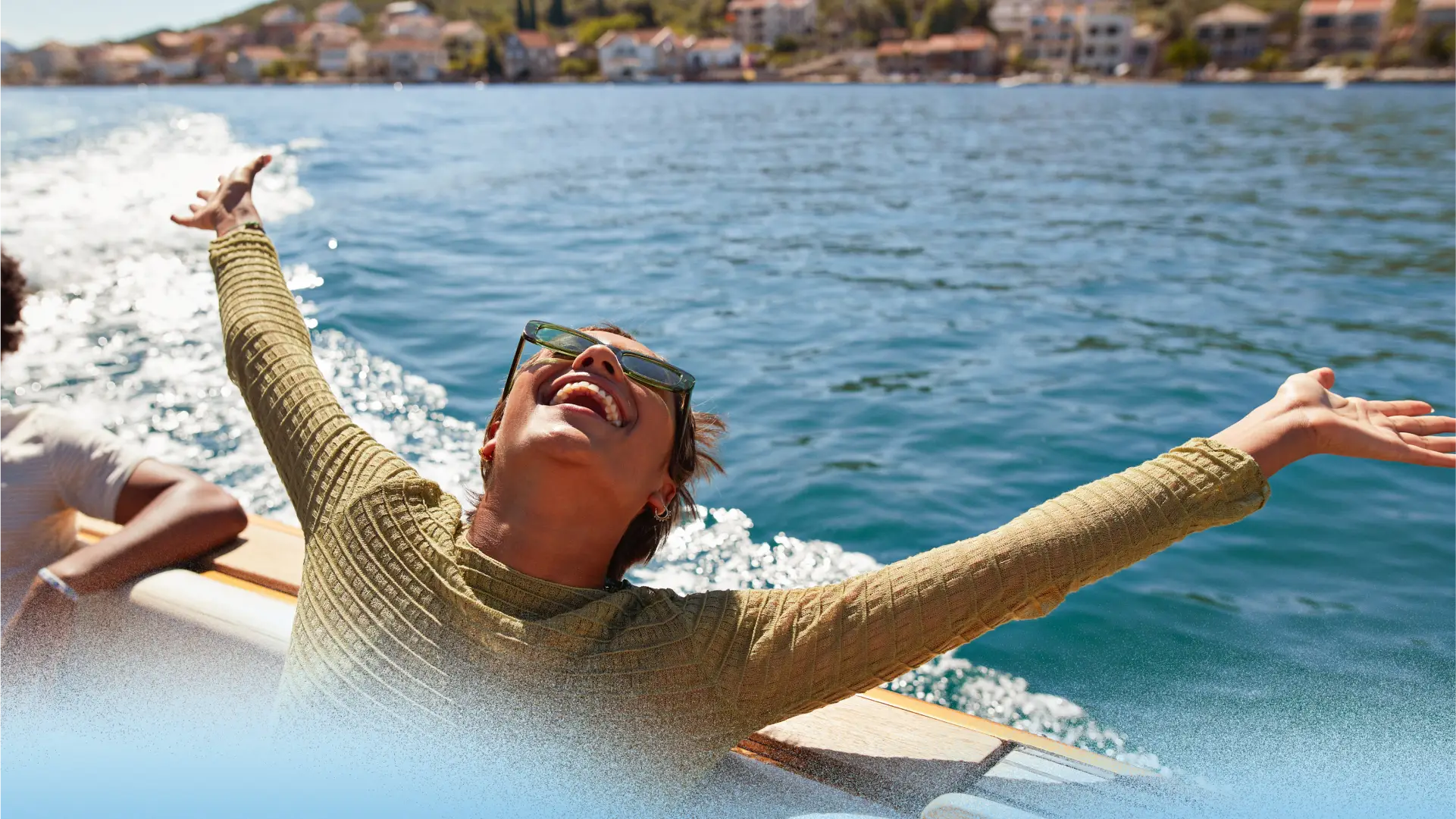 A woman with arms up on a boat.