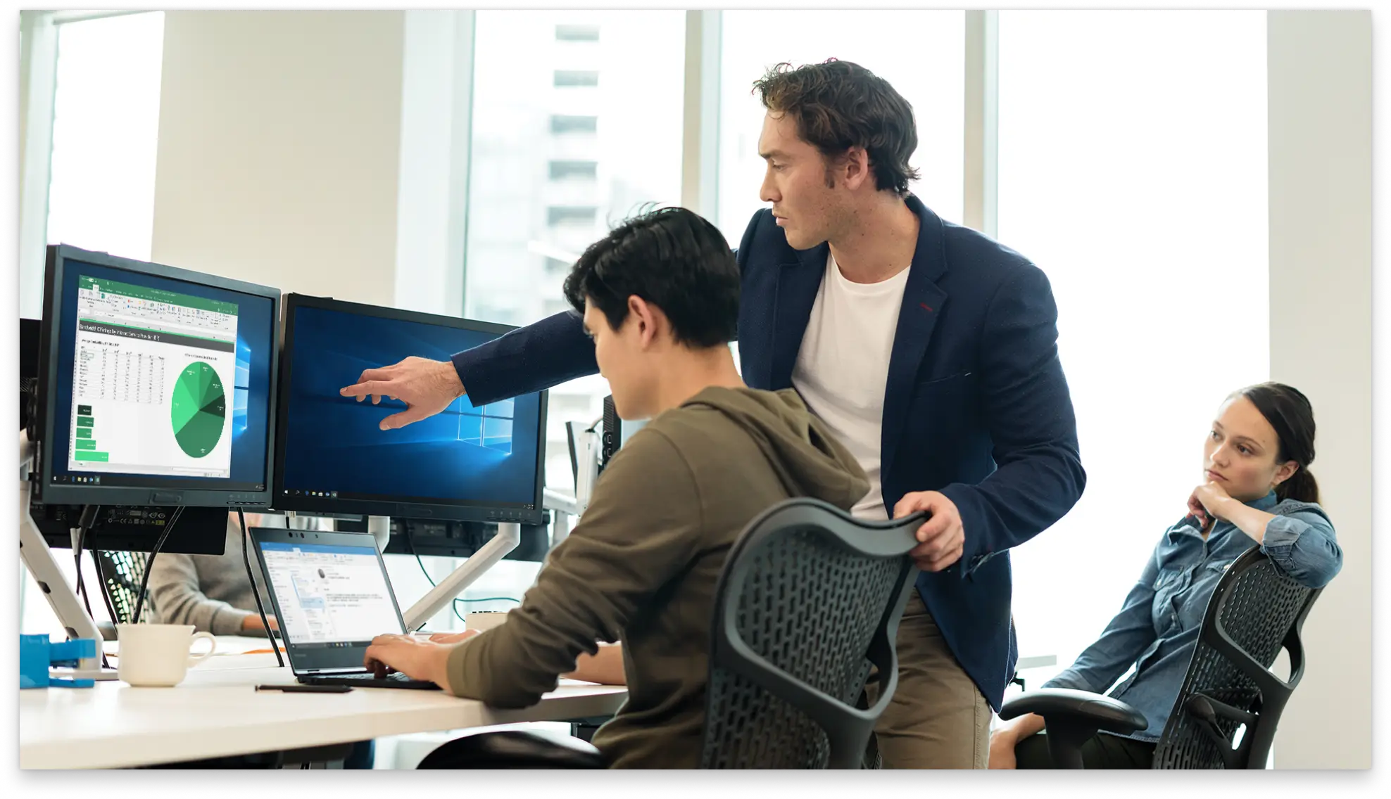 Two people analyzing financial data on computer screens in an office setting.