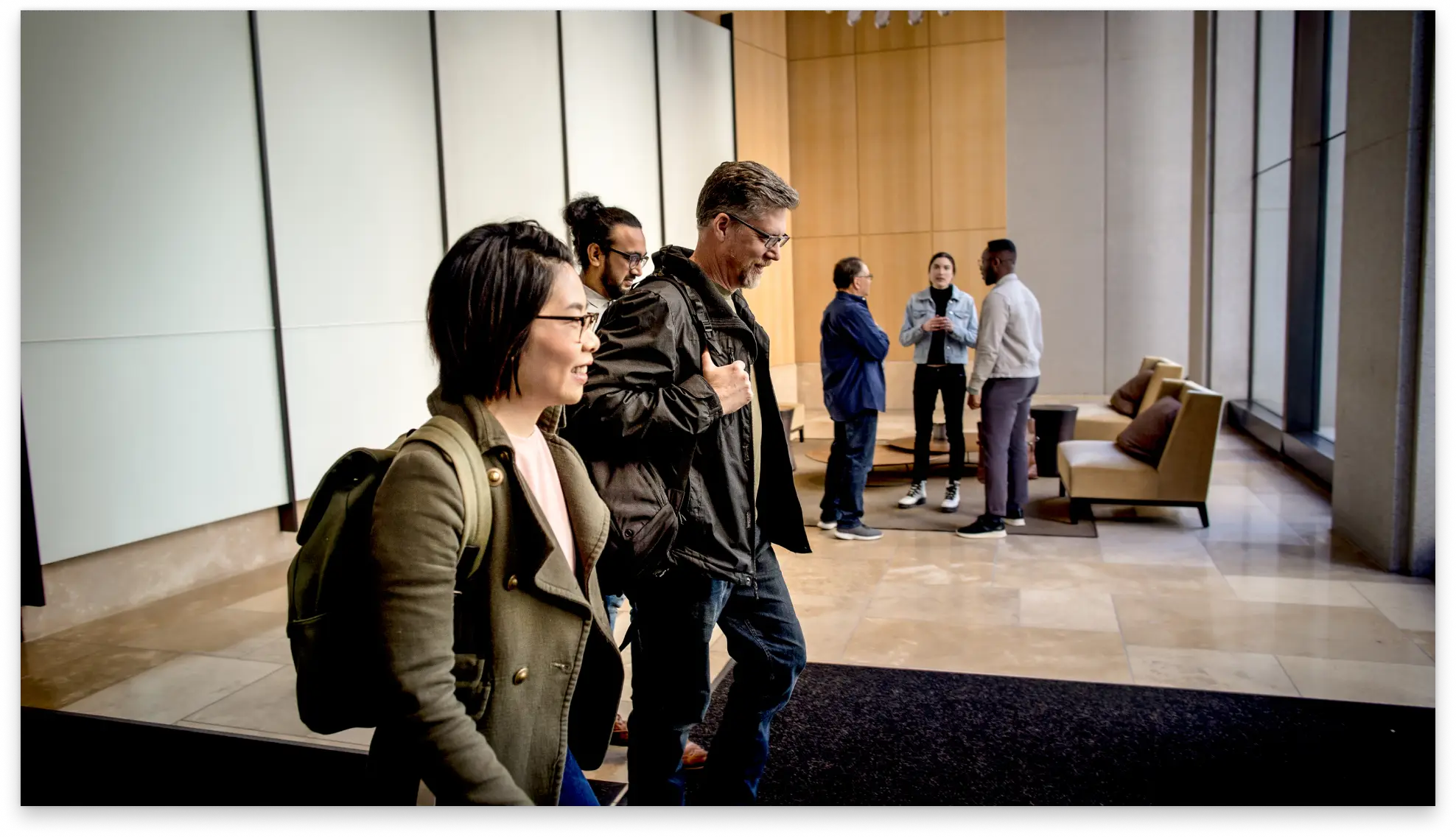 Three people walking through an office hallway 