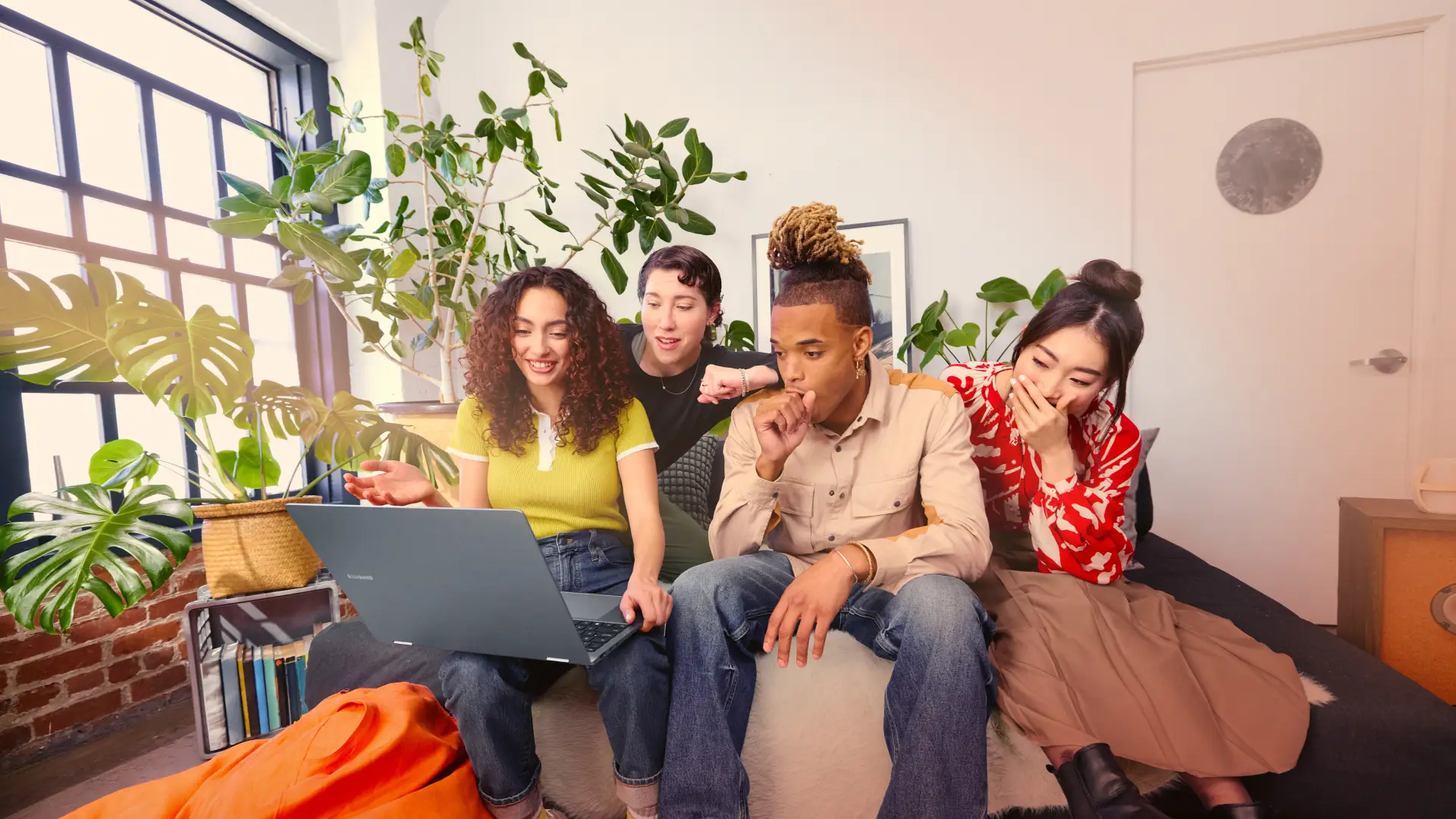 A group of people looking at a laptop in a bright office