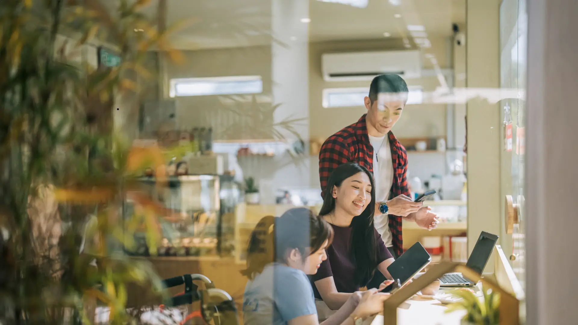 Three people discussing a topic at the computer.