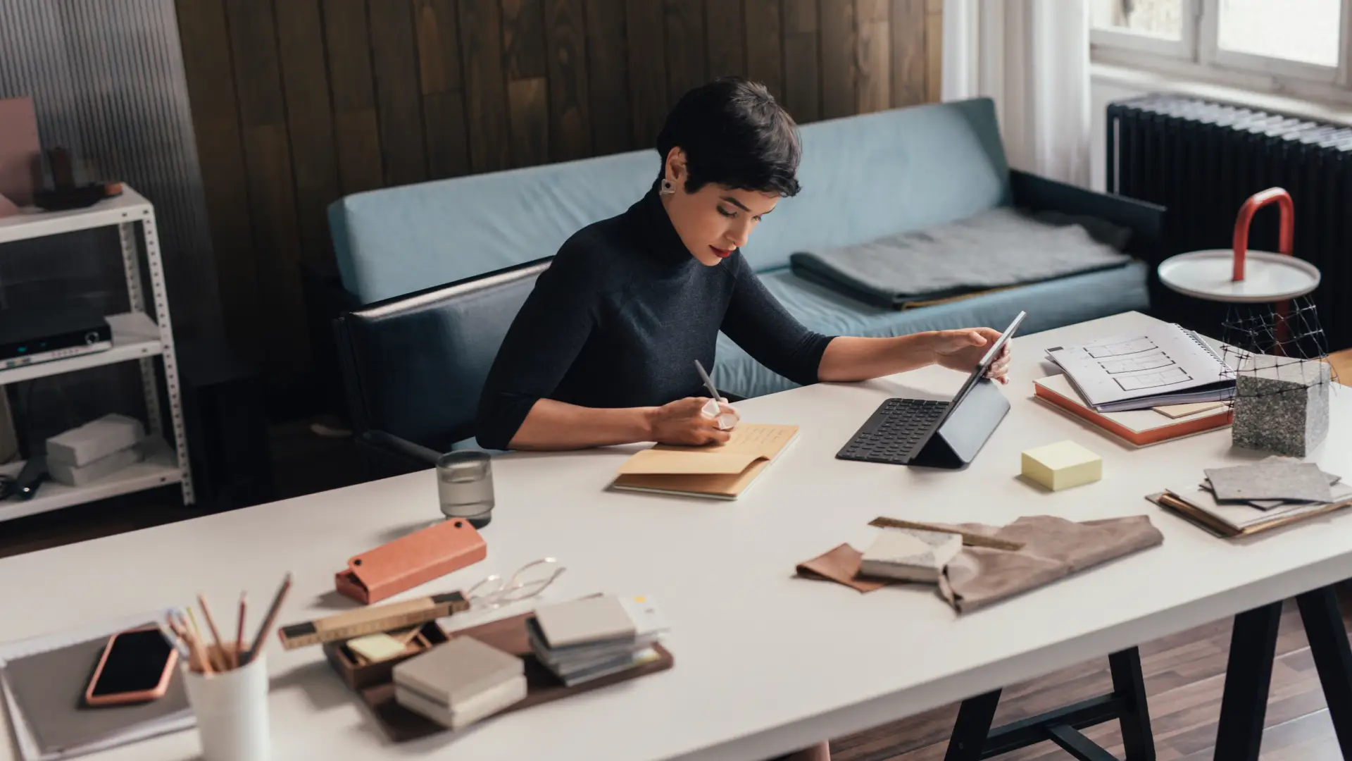 A woman sitting at a desk writing notes.