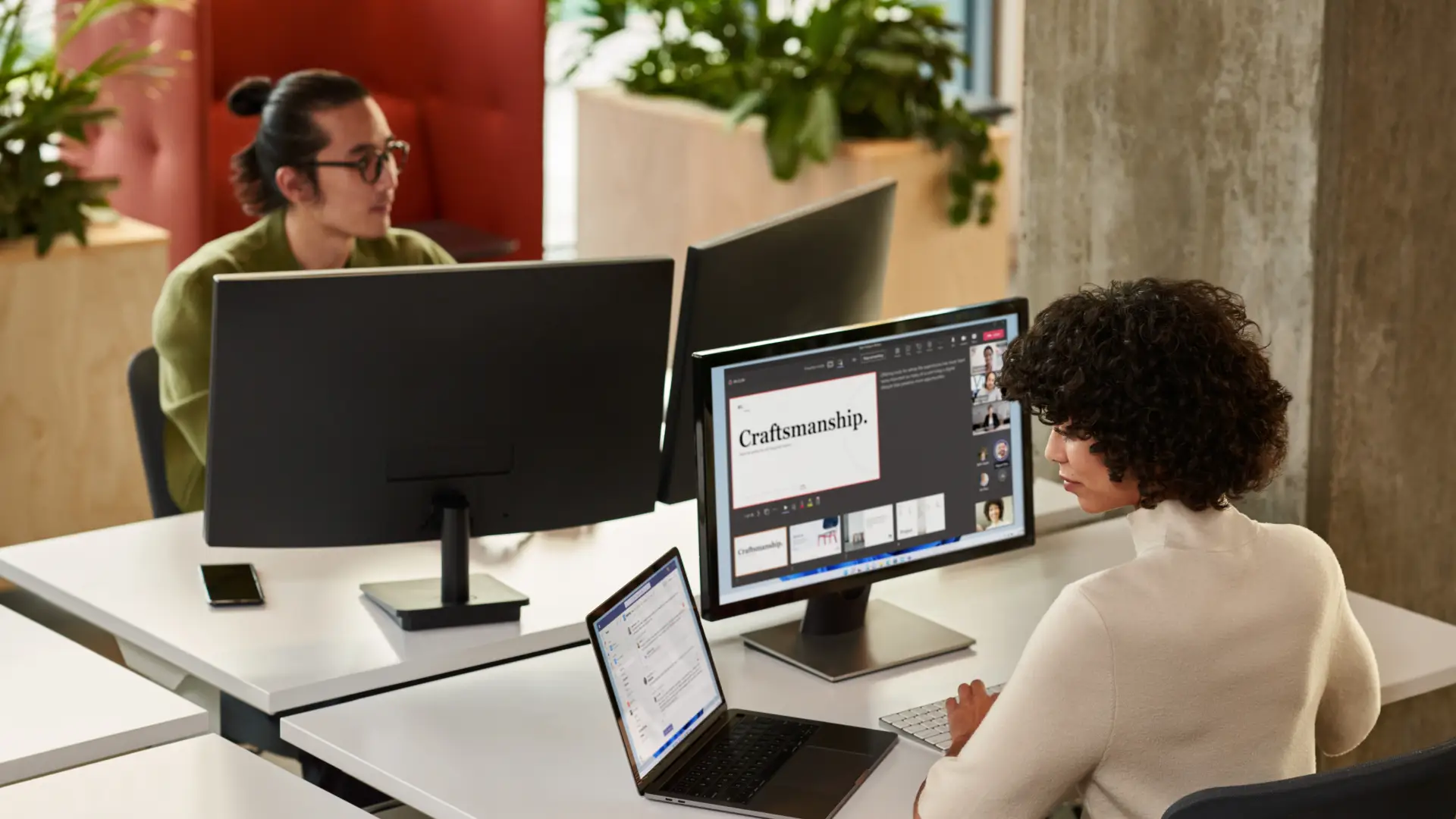 Two people in an office working on computers